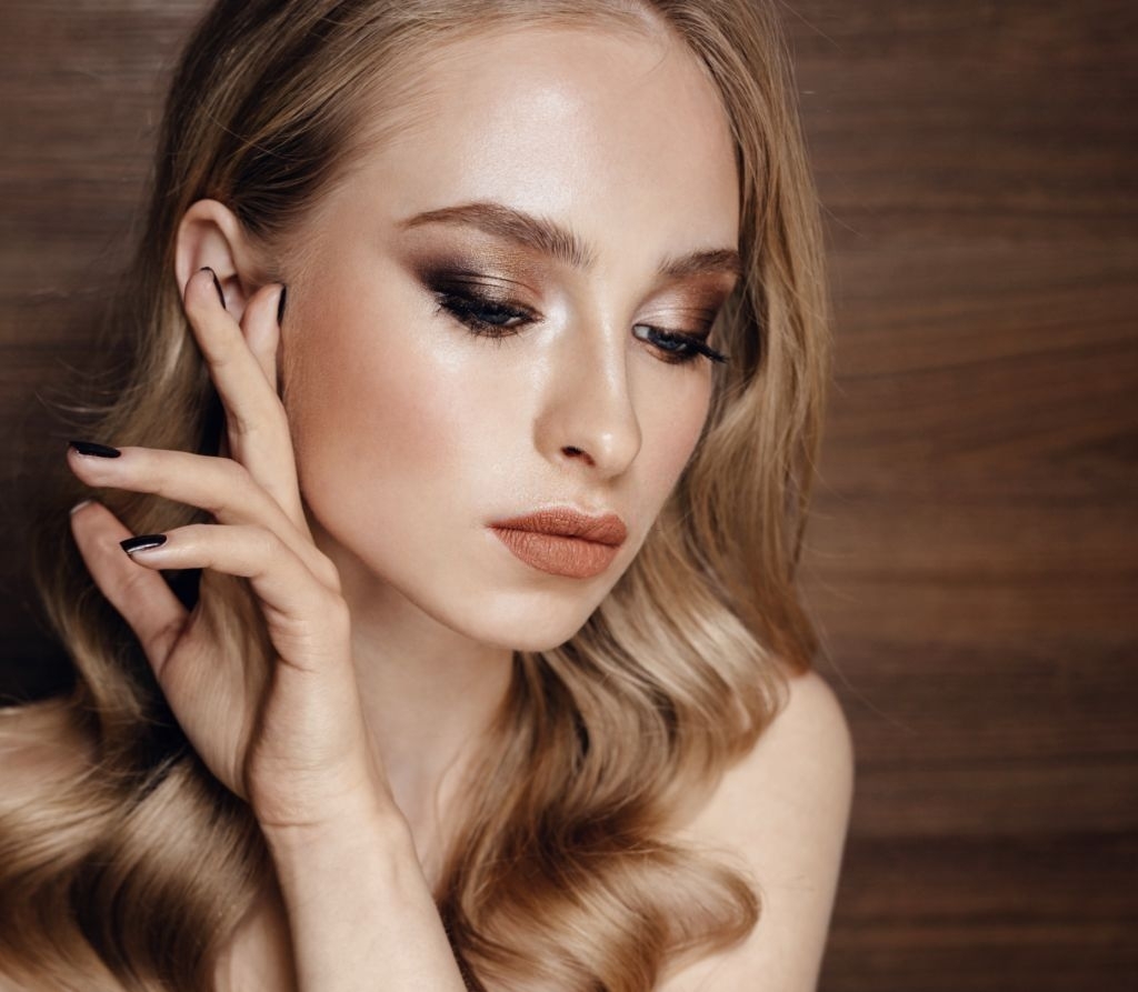A blonde woman with makeup modelling.