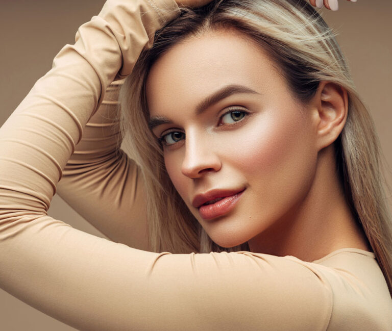 A woman with Kybella treatment smiling at the camera.