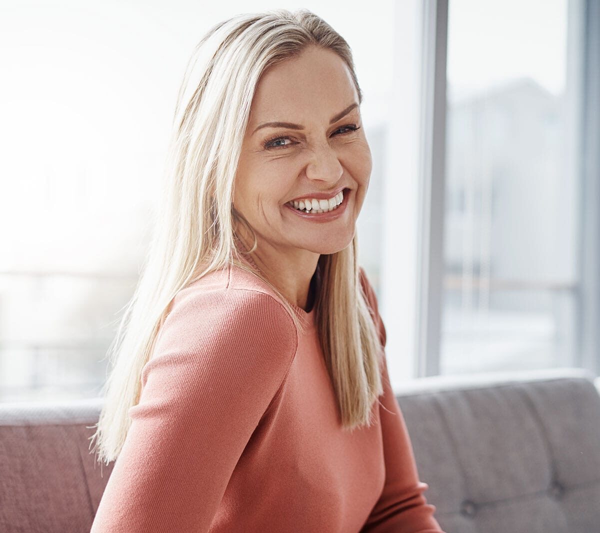 A blonde woman winking at the camera.