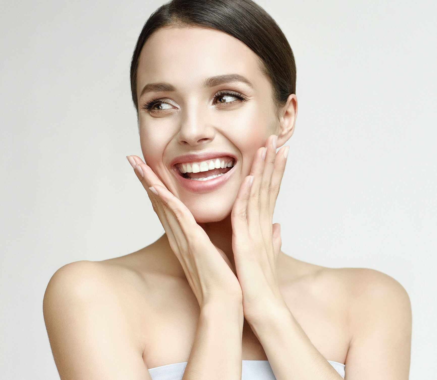 A woman smiling looking to the side.