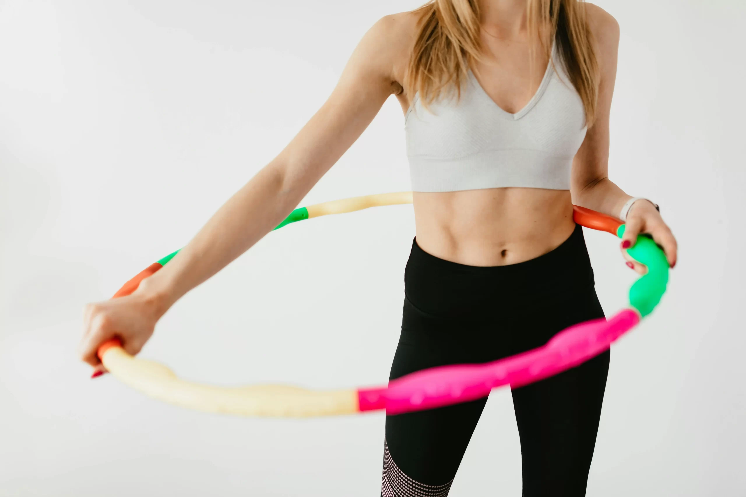 A fit woman with a hula hoop around her waist.