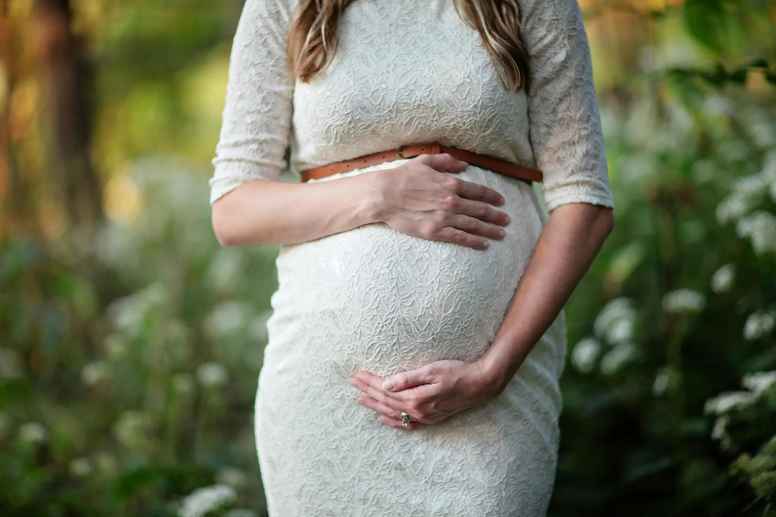 A pregnant woman holding her belly.