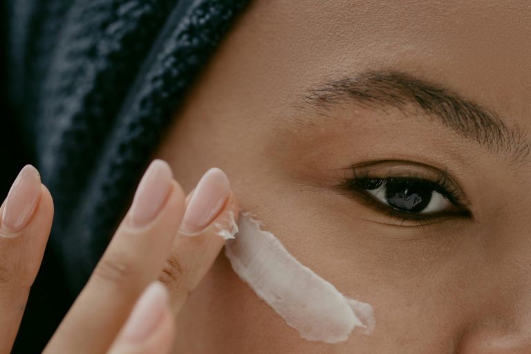 Woman putting lotion on her cheek