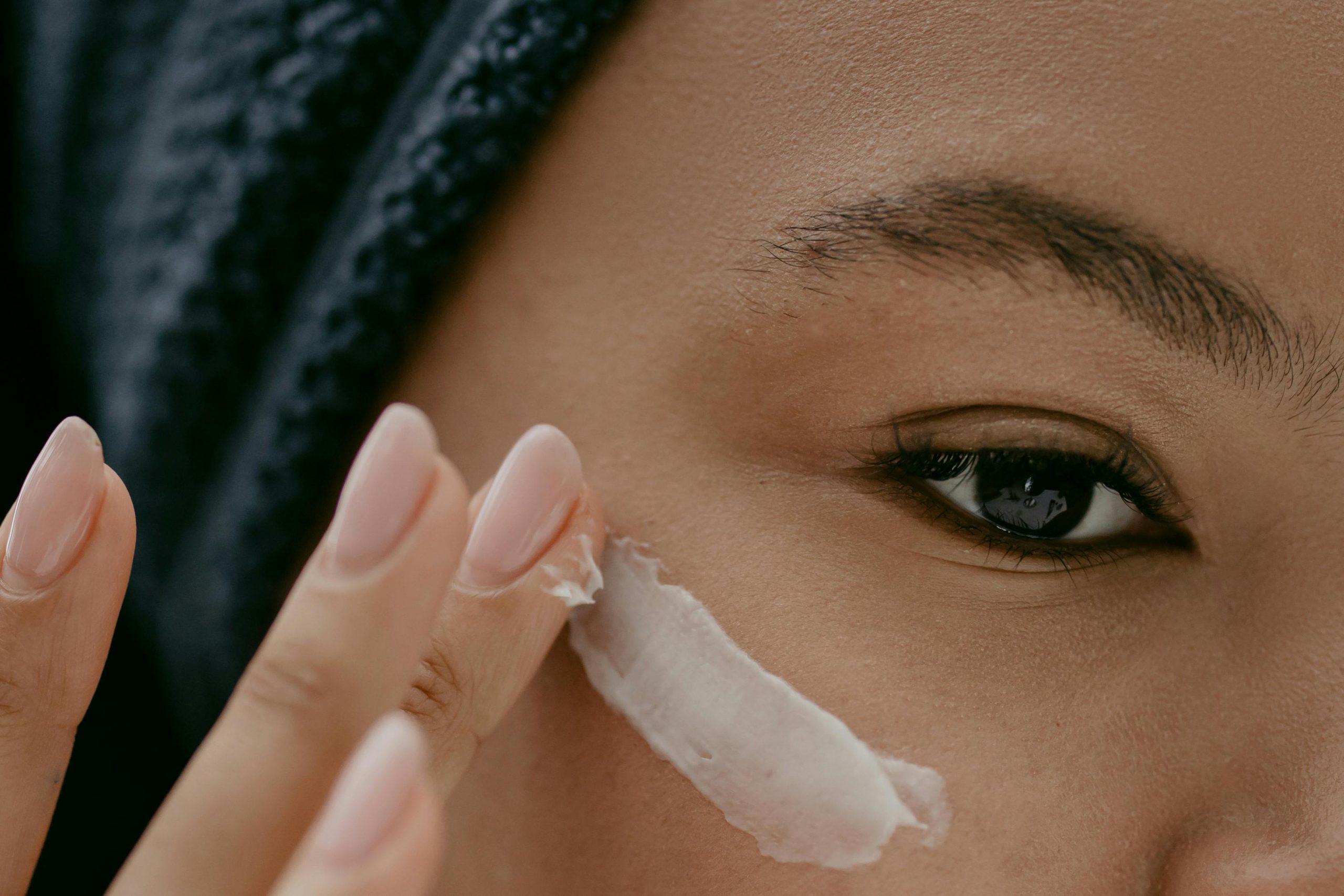 Woman putting lotion on her cheek