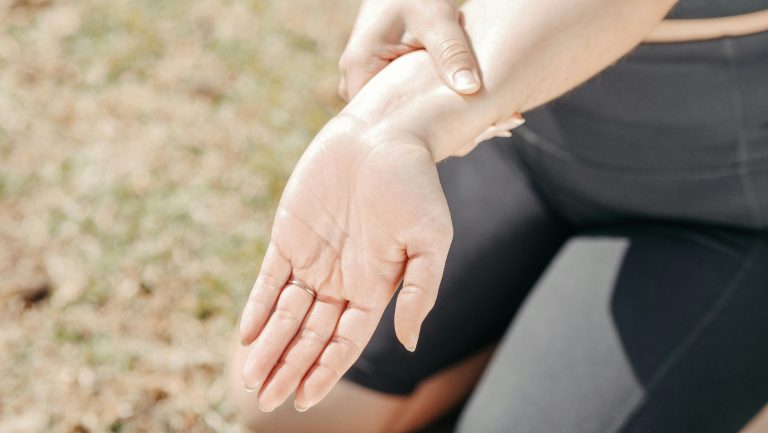 Person holding their wrist in pain